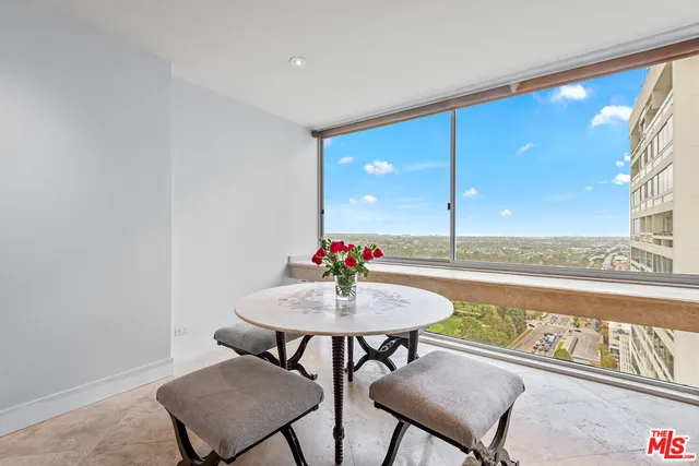 a dining room with furniture and a floor to ceiling window
