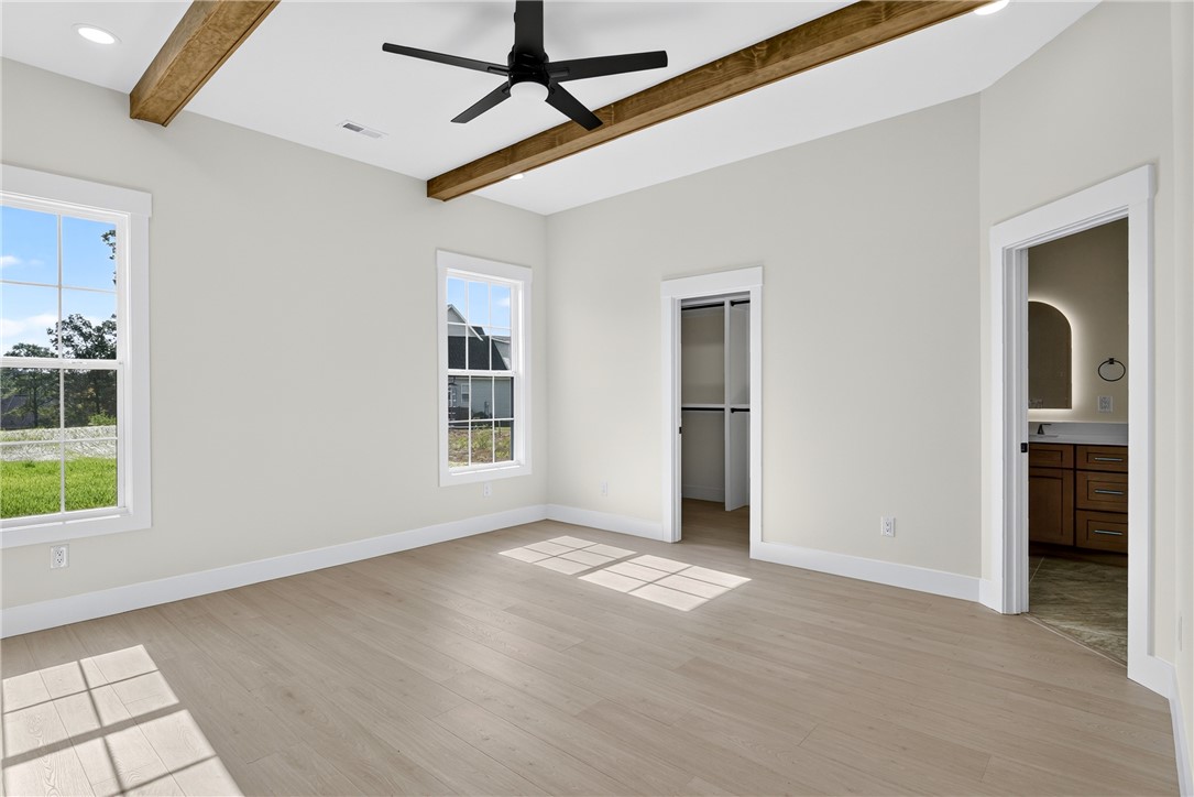 414 Blume Road Anderson, SC 29625 - Photo 32 of 50 Exposed wood beams and light-toned flooring elevate this spacious primary suite design.