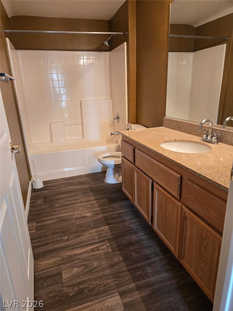 10550 West Alexander Road, Unit 1040 Las Vegas, NV 89129 - Photo 16 of 18 Rich wood plank flooring coordinates beautifully with the warm vanity cabinetry in this full bath.