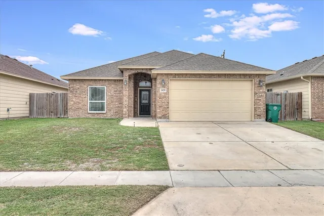 a front view of a house with a garden and yard