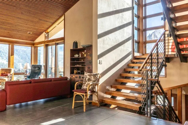 a view of staircase with a rug and a large window