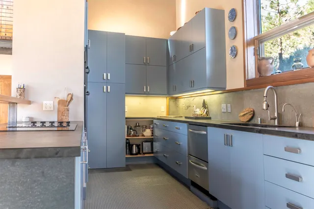 a kitchen with stainless steel appliances granite countertop a sink and a stove next to a window