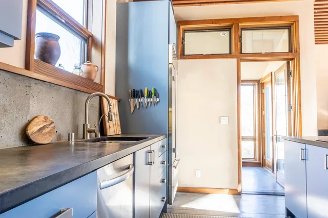 a view of kitchen with granite countertop a sink and a window