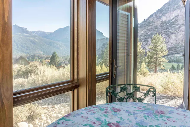 a bedroom with a bed and large windows