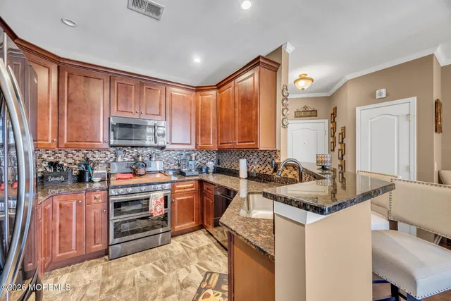 a kitchen with stainless steel appliances granite countertop a sink stove and cabinets