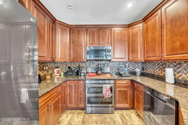 a kitchen with stainless steel appliances wooden cabinets and a stove top oven