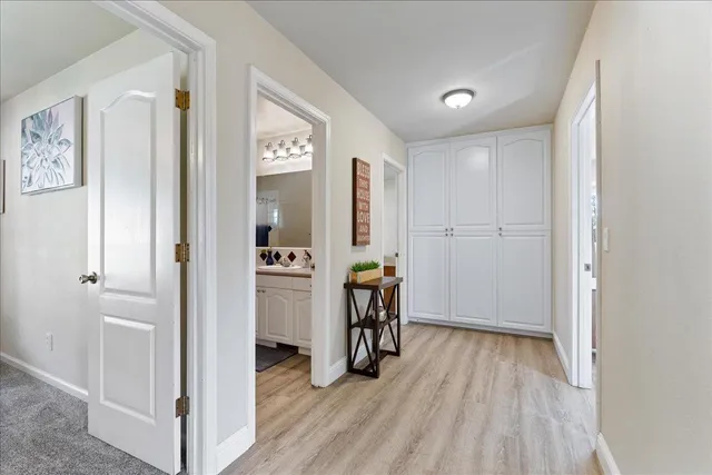 a view of a hallway with bathroom and wooden floor