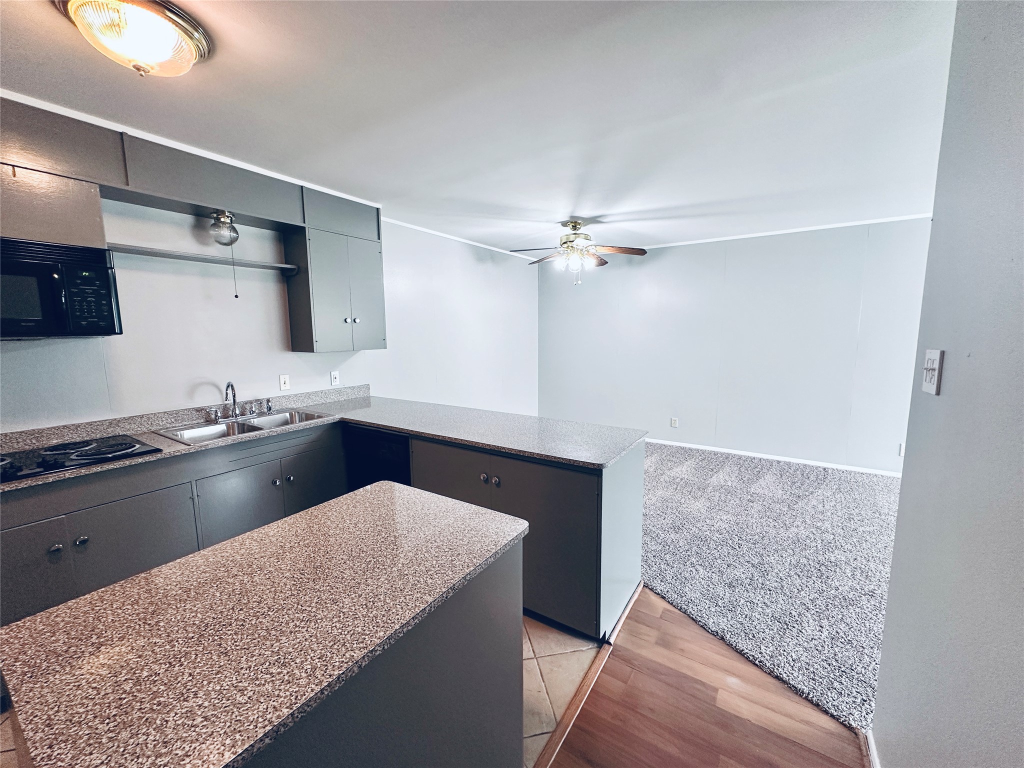 a kitchen with granite countertop a sink stainless steel appliances and cabinets