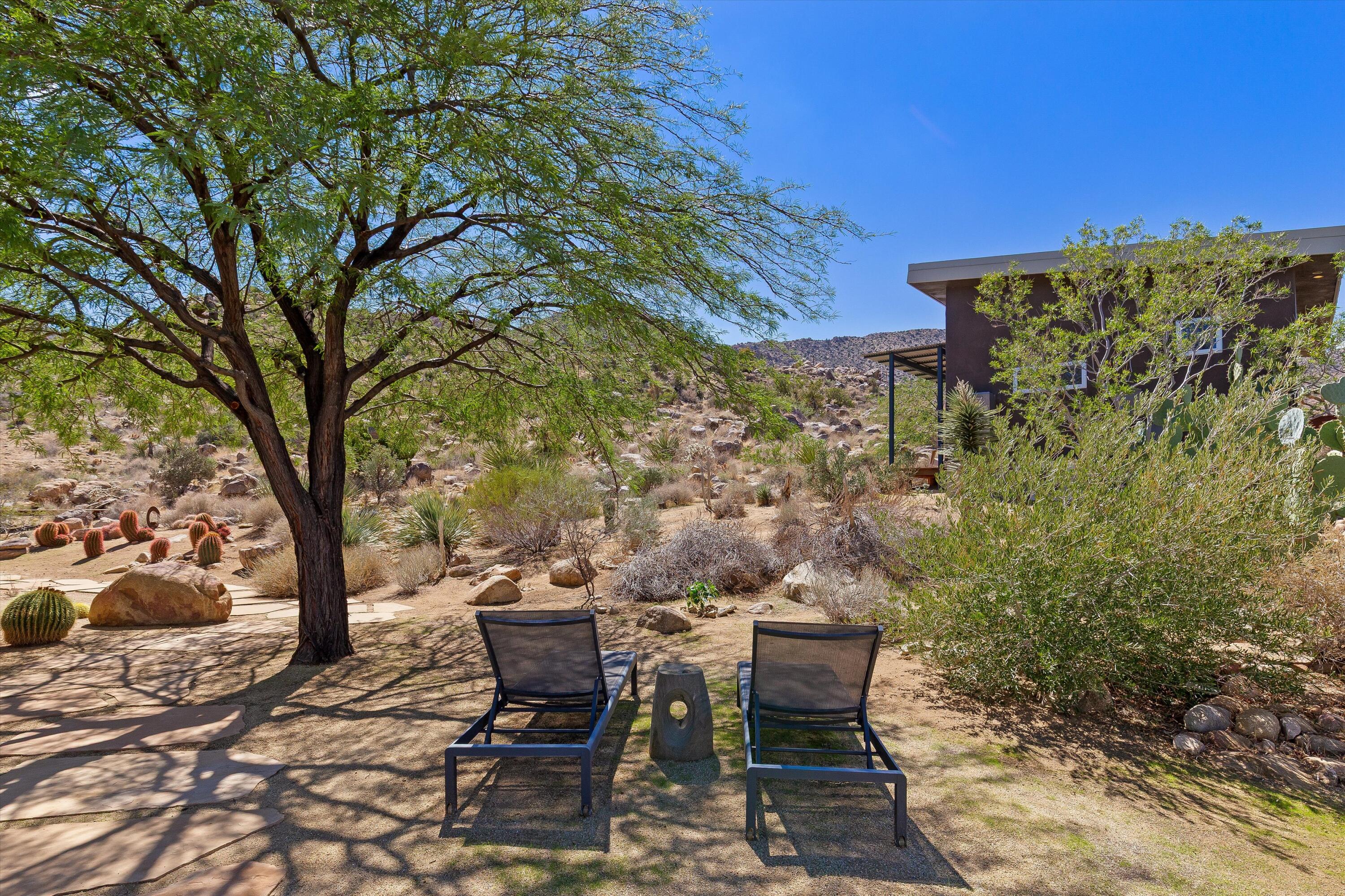 8744 Star Lane Joshua Tree, CA 92252 - Photo 11 of 55 a view of a backyard with table and chairs and potted plants