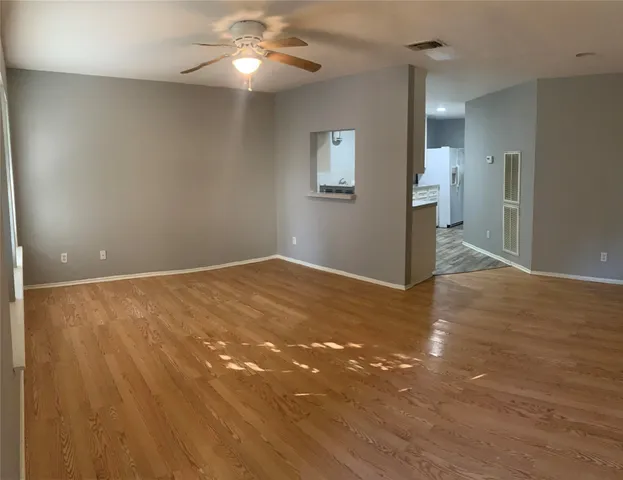 a view of empty room with wooden floor