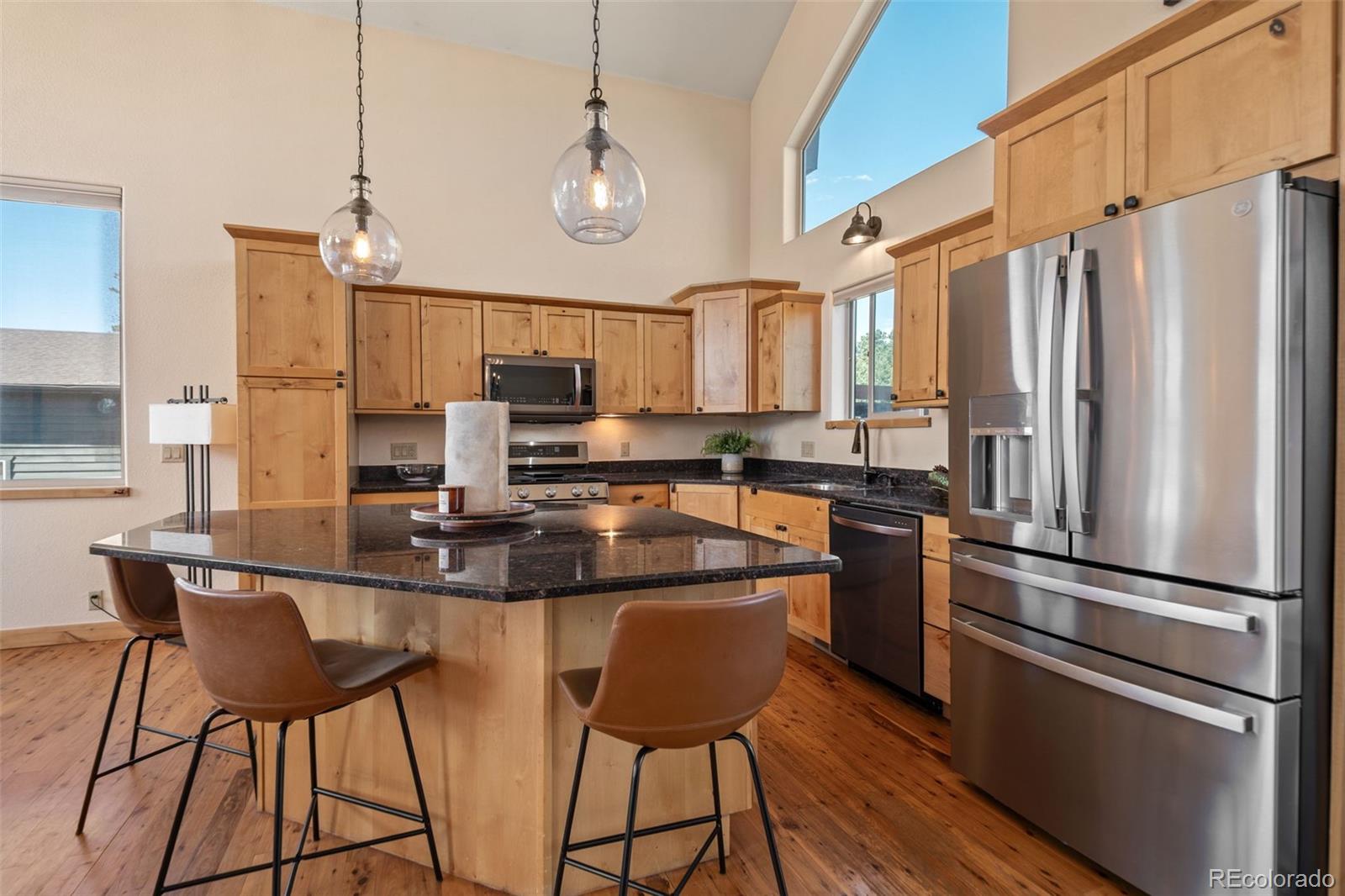 7102 Lynx Lair Road Evergreen, CO 80439 - Photo 12 of 42 a kitchen with stainless steel appliances a refrigerator a stove a sink and chairs