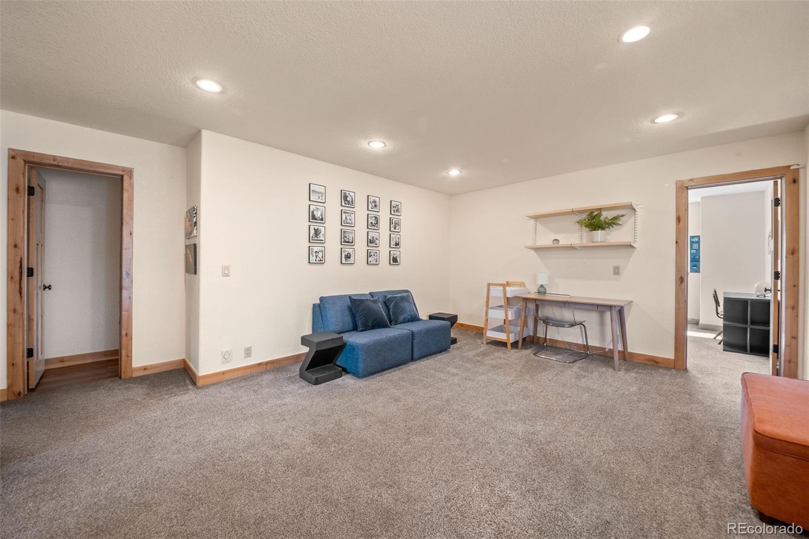 7102 Lynx Lair Road Evergreen, CO 80439 - Photo 13 of 42 a living room with furniture and a flat screen tv