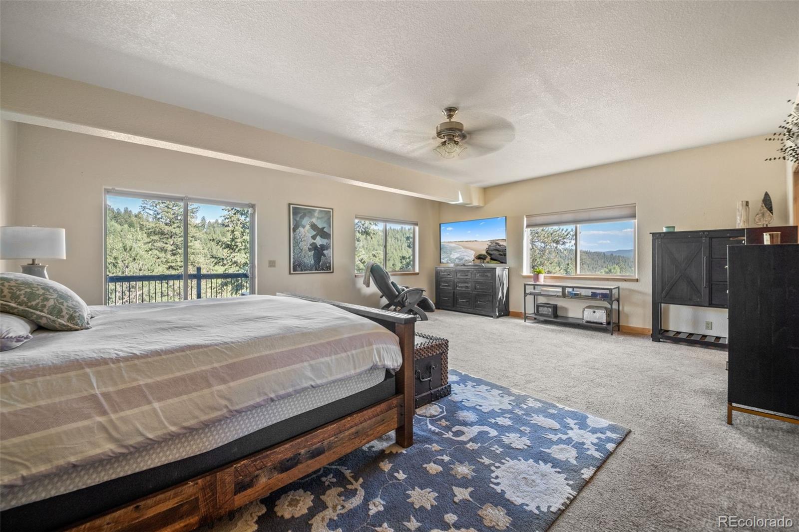 7102 Lynx Lair Road Evergreen, CO 80439 - Photo 15 of 42 a bed sitting in a spacious bedroom next to a window