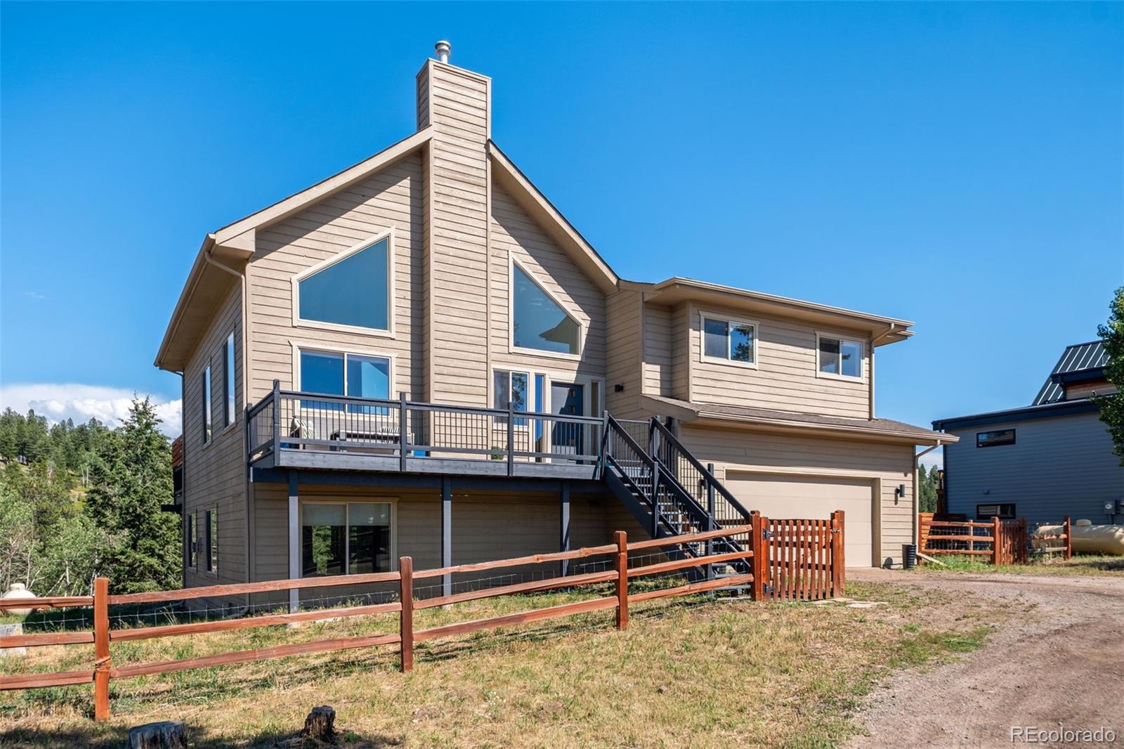 7102 Lynx Lair Road Evergreen, CO 80439 - Photo 37 of 42 a view of a house with windows and wooden fence