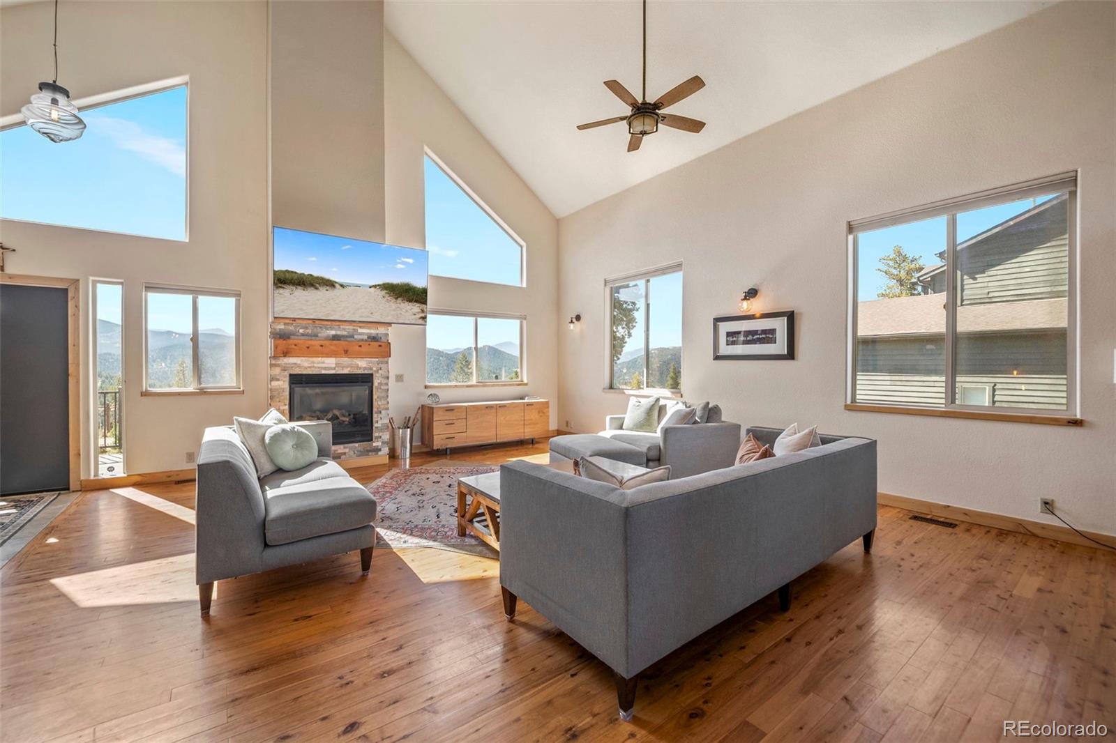7102 Lynx Lair Road Evergreen, CO 80439 - Photo 5 of 42 a living room with fireplace furniture and a large window