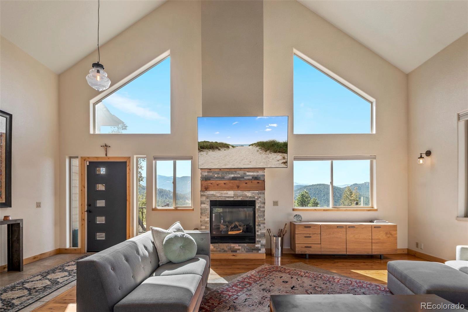 7102 Lynx Lair Road Evergreen, CO 80439 - Photo 6 of 42 a living room with furniture and a fireplace