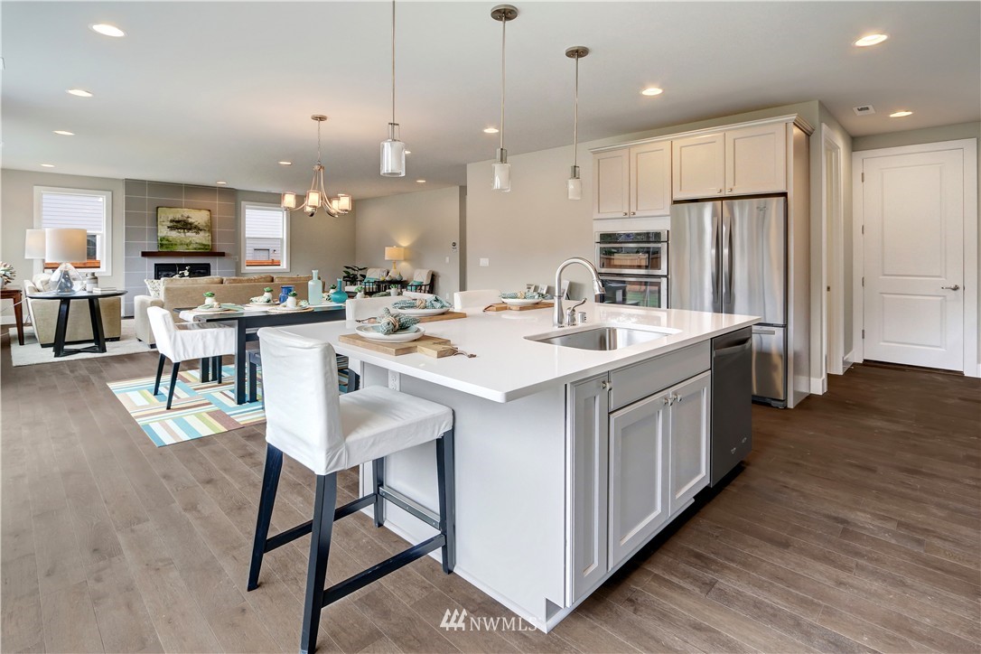 322 Field Place Southeast Renton, WA 98059 - Photo 8 of 25 a kitchen with stainless steel appliances a stove a sink a kitchen island with chairs and wooden floor