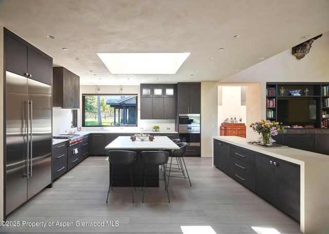a bathroom with a granite countertop sink and a large mirror next to a window