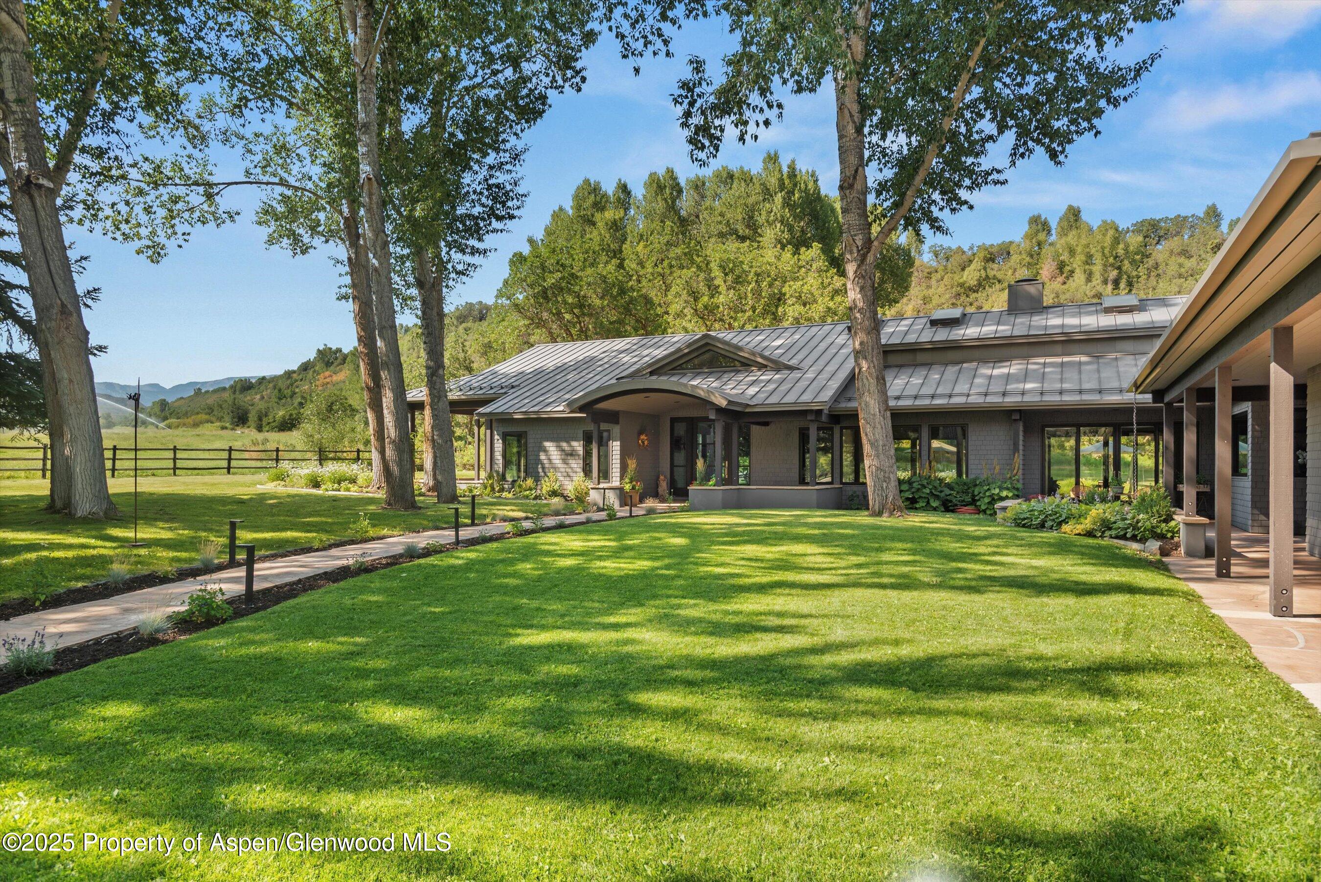 3333 Snowmass Creek Road Snowmass, CO 81654 - Photo 10 of 43 a front view of a house with a garden