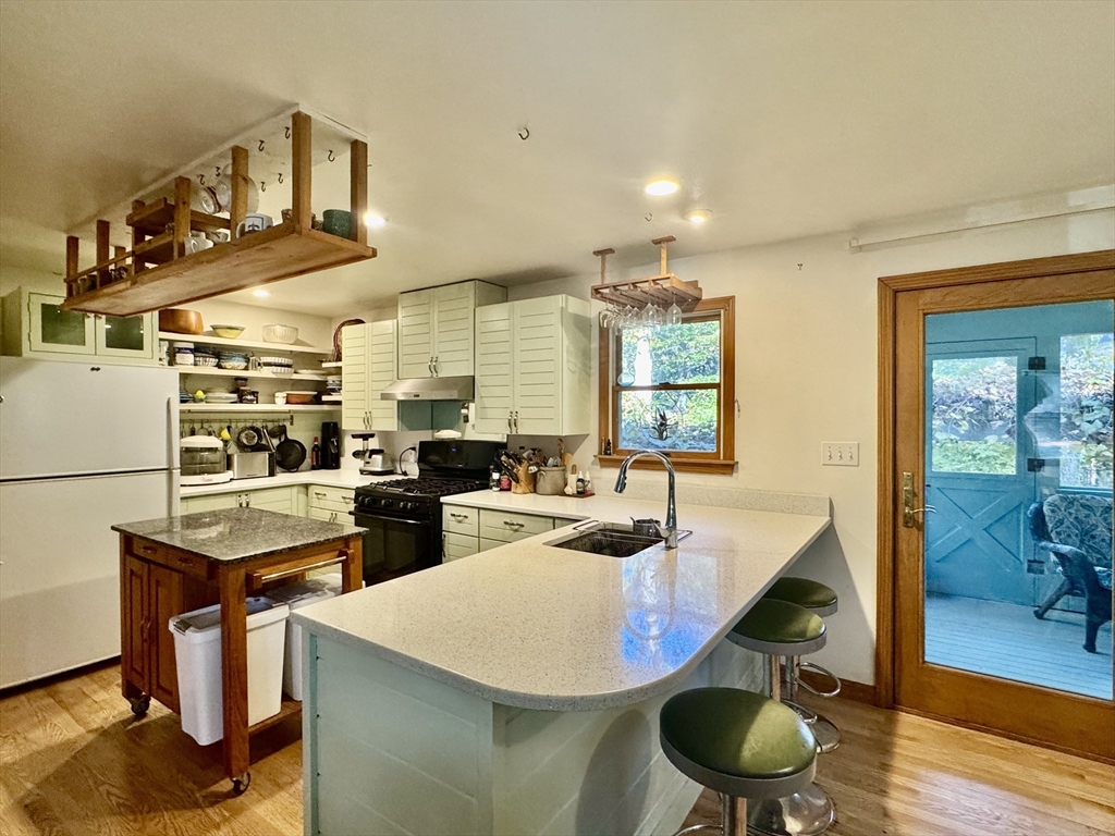 113 Leonard Circle Tisbury, MA 02568 - Photo 3 of 25 a room with stainless steel appliances kitchen island granite countertop a sink a stove and a wooden floors