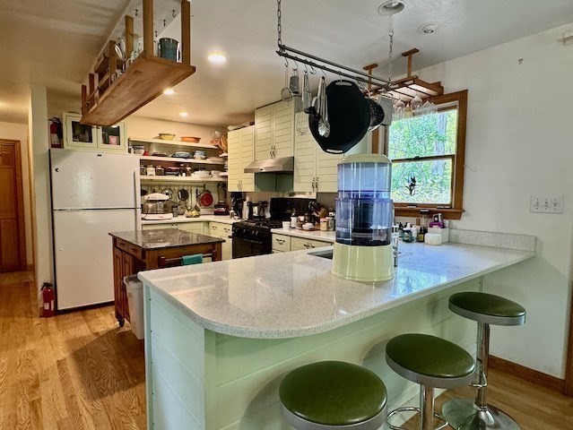 113 Leonard Circle Tisbury, MA 02568 - Photo 6 of 25 a kitchen with stainless steel appliances granite countertop a sink a stove and chairs