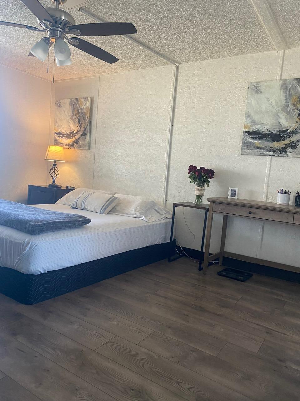 8300 Kern Canyon Road Bakersfield, CA 93306 - Photo 9 of 10 a spacious bedroom with a bed and a chandelier