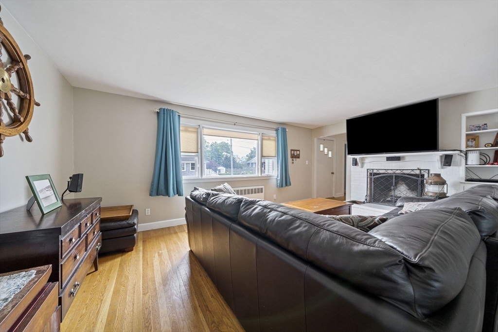 15 D Street Hull, MA 02045 - Photo 6 of 42 a living room with a bed a flat screen tv and a fireplace
