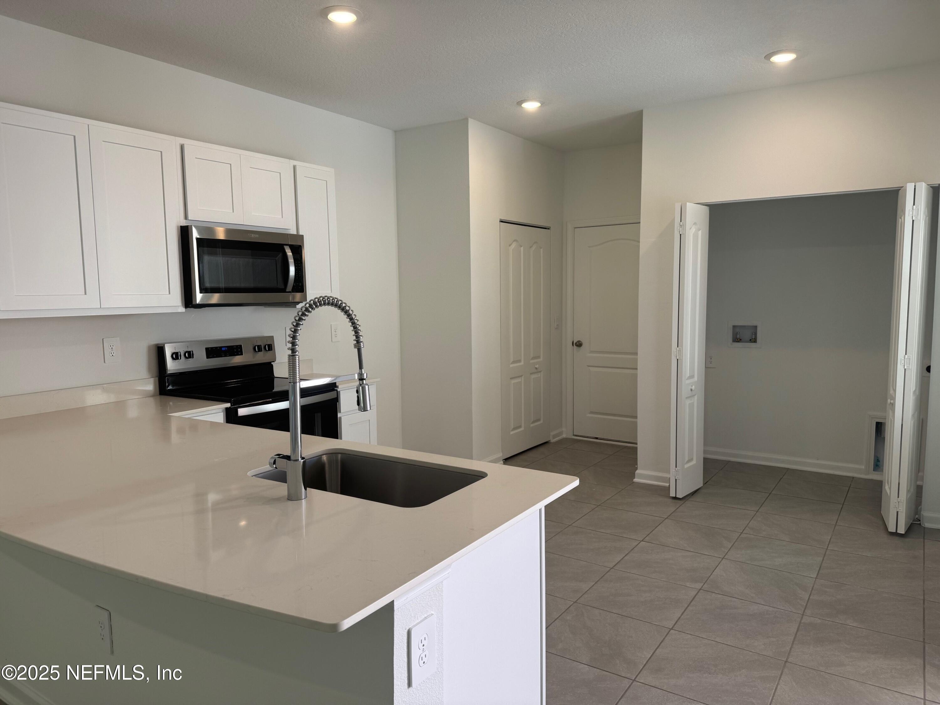 67 Blue Hvn Road St. Augustine, FL 32095 - Photo 6 of 58 a kitchen with a sink a stove and cabinets