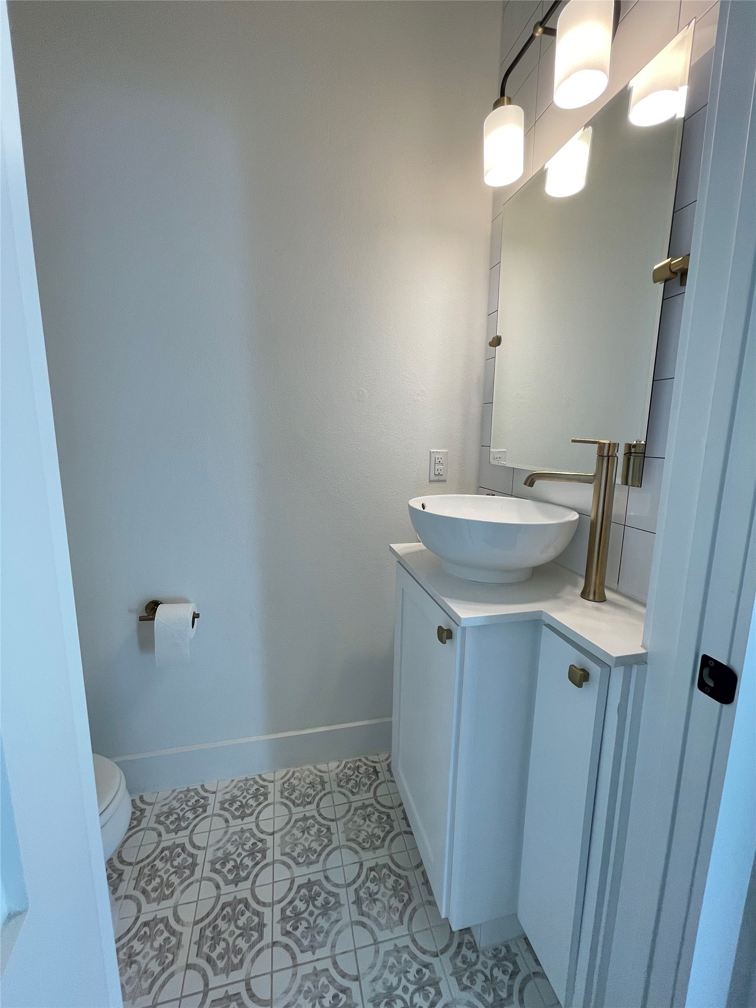 1106 Walton Lane, Unit B Austin, TX 78721 - Photo 12 of 28 Half bathroom downstairs with vanity and light tile patterned floors