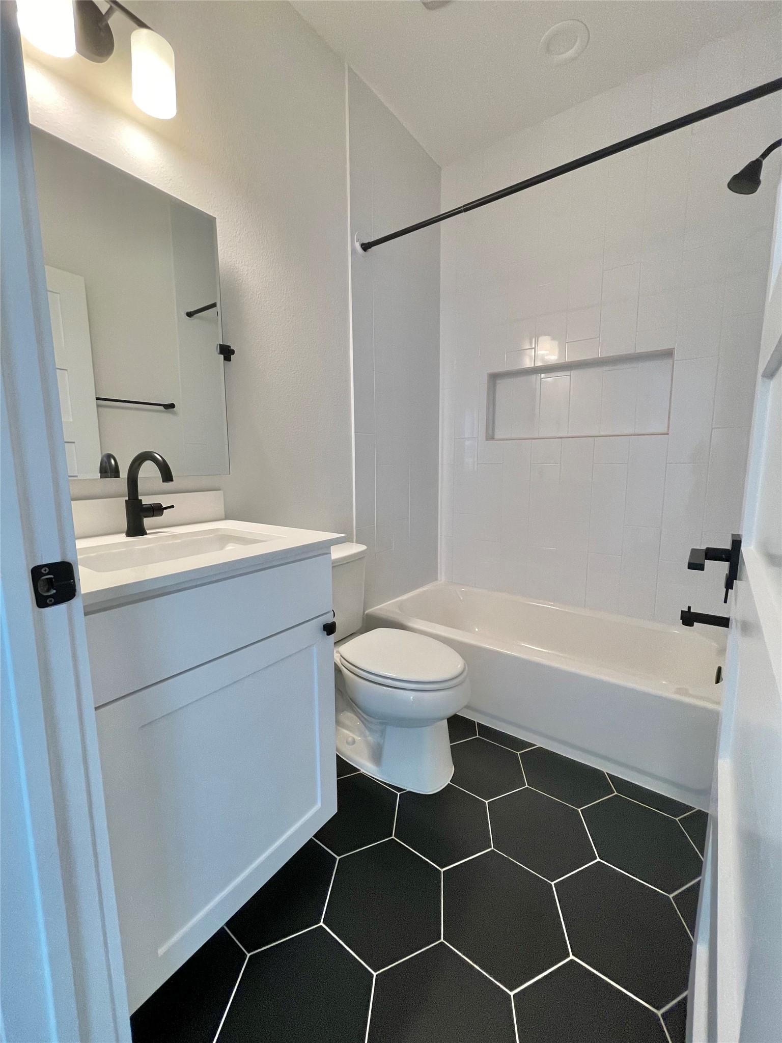 1106 Walton Lane, Unit B Austin, TX 78721 - Photo 19 of 28 Bathroom with vanity, bathtub / shower combination, and dark tile patterned flooring