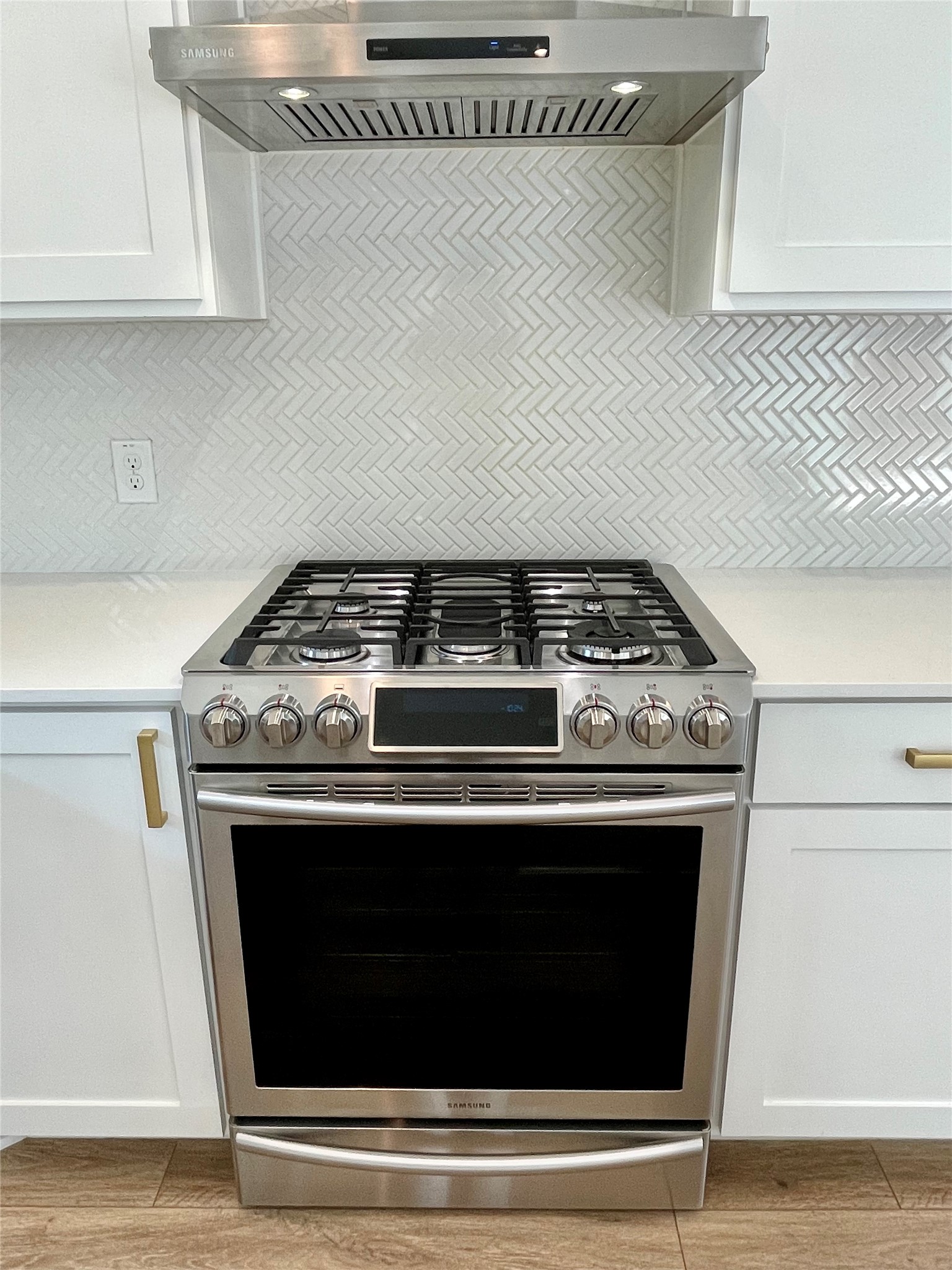 1106 Walton Lane, Unit B Austin, TX 78721 - Photo 8 of 28 Kitchen featuring extractor fan, white cabinets, stainless steel range with gas stovetop, and backsplash
