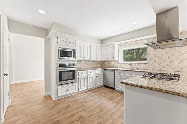 a kitchen with granite countertop a stove a sink and a microwave