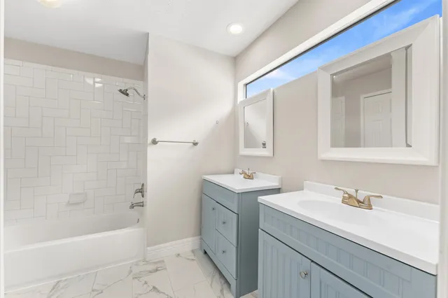 a bathroom with a tub sink and mirror