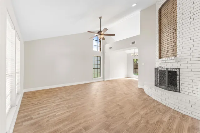 a view of an empty room with a fireplace and a window