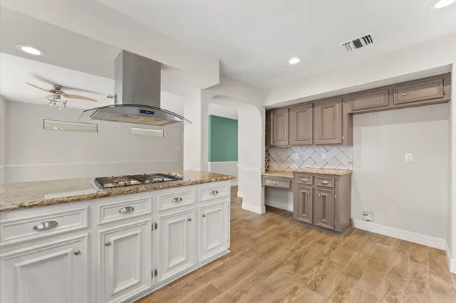 a kitchen with granite countertop a sink stove and cabinets