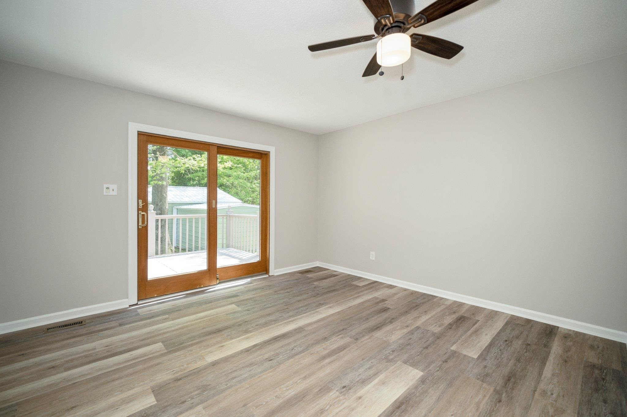 5504 Old Forge Circle Raleigh, NC 27609 - Photo 15 of 34 Beautiful Anderson sliding glass door fills the room with light. Love the new LVP flooring and interior paint. Primary Bedroom Opens to the Deck