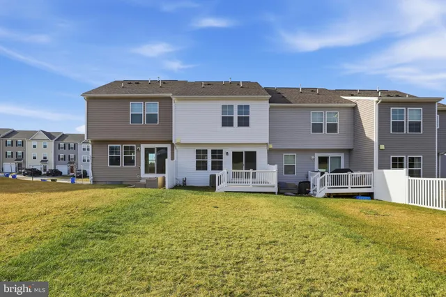 a view of a large pool with lawn chairs and a yard