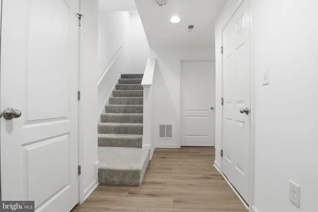 a view of a hallway with wooden floor and entryway