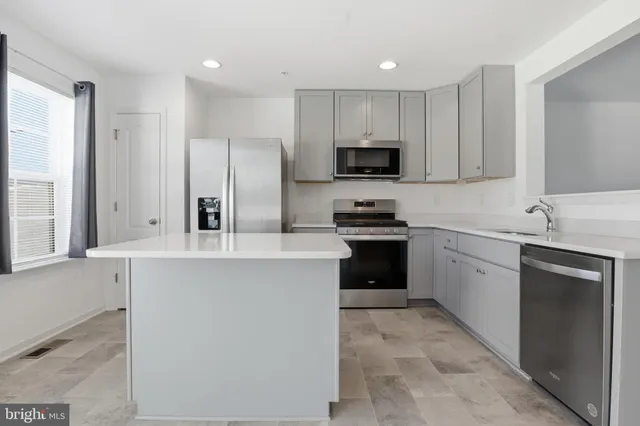 a kitchen with stainless steel appliances a refrigerator sink and cabinets