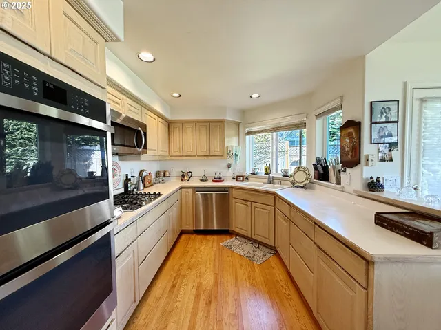 a large kitchen with stainless steel appliances granite countertop a lot of counter space and a sink