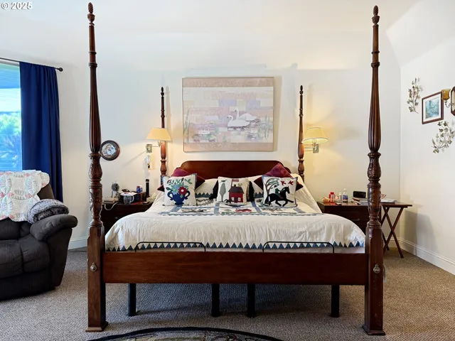 a bedroom with a bed lamp and a large window