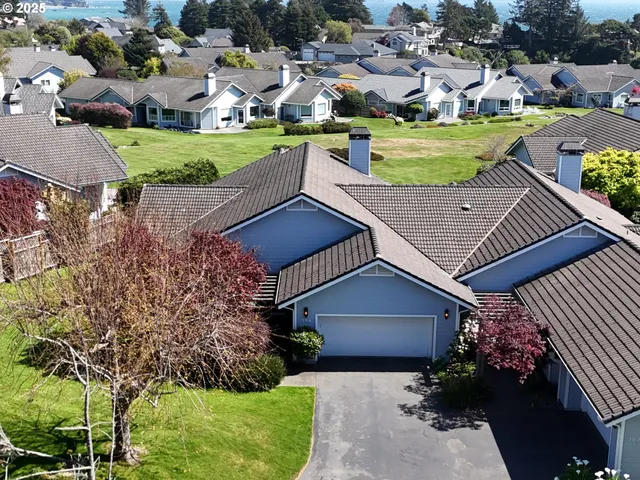 an aerial view of a house with a garden and lake view