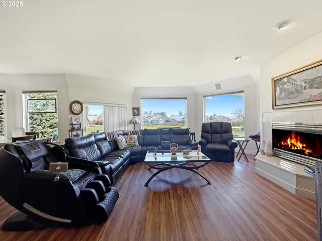 a living room with furniture fireplace and wooden floor