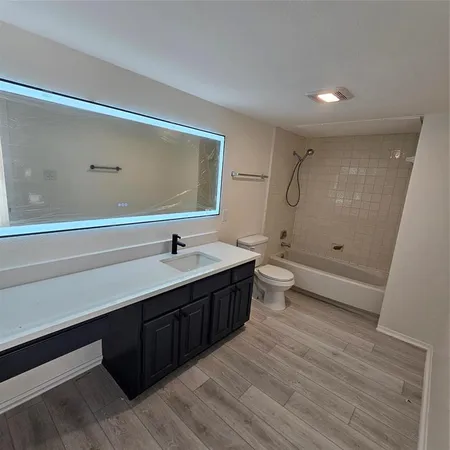 a bathroom with a double vanity sink toilet and shower