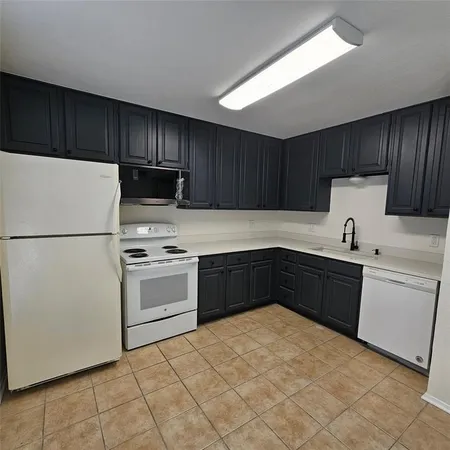 a kitchen with a refrigerator and a stove top oven