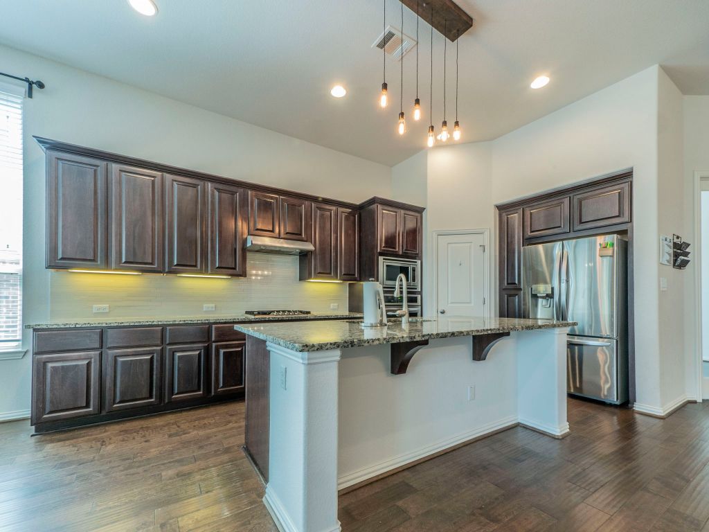 244 Fort Cobb Way Georgetown, TX 78628 - Photo 3 of 29 a kitchen with stainless steel appliances granite countertop a sink a stove and a refrigerator