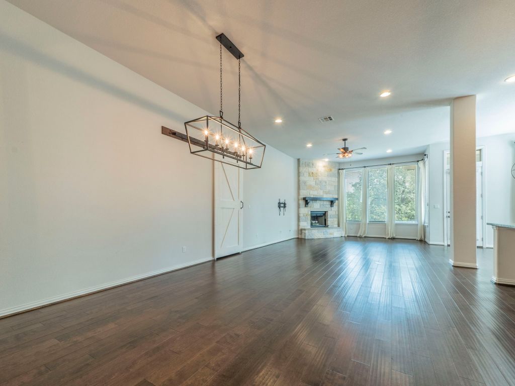 244 Fort Cobb Way Georgetown, TX 78628 - Photo 7 of 29 a view of a room with wooden floor gym equipment and a ceiling fan