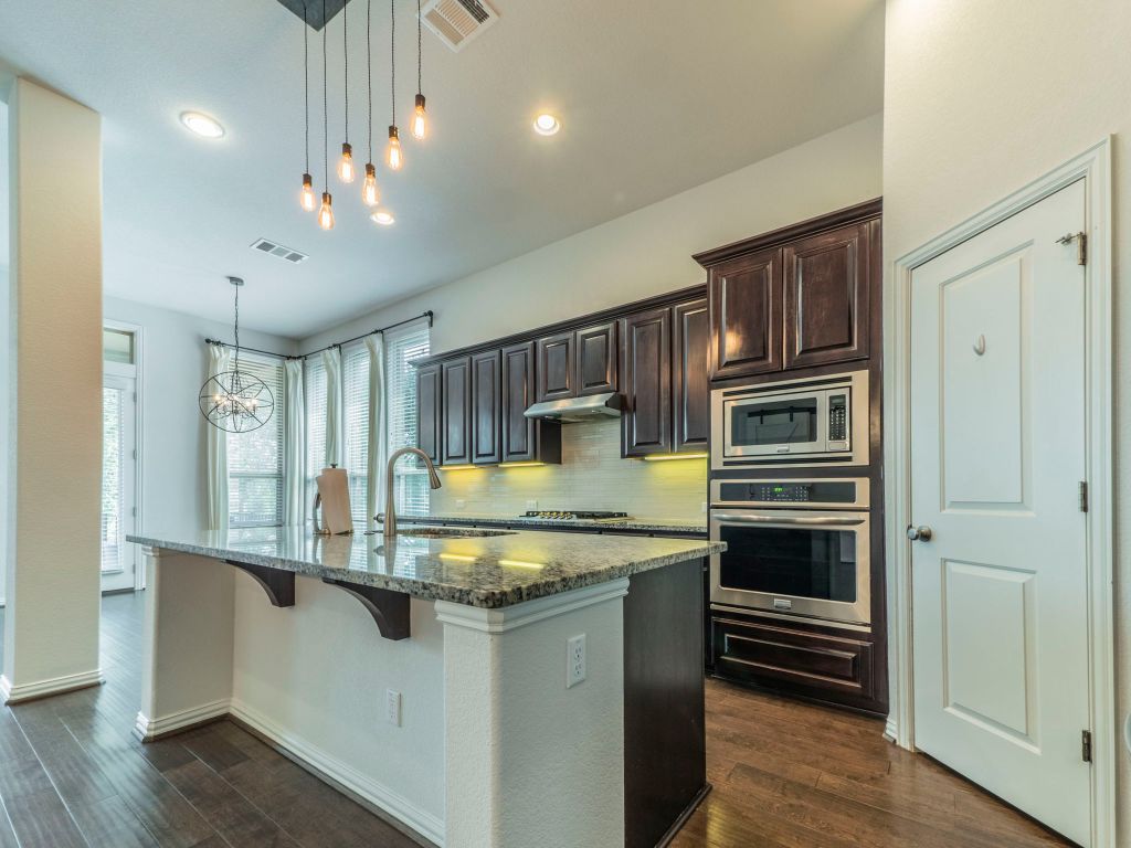 244 Fort Cobb Way Georgetown, TX 78628 - Photo 9 of 29 a kitchen with kitchen island granite countertop a sink cabinets and stainless steel appliances