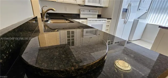 a kitchen with stainless steel appliances white cabinets and a refrigerator