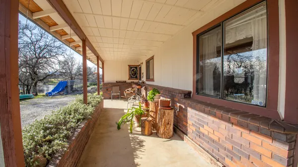 a view of a porch with wooden floor and a potted plant